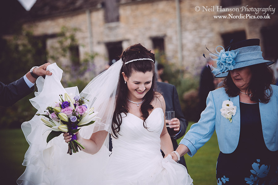 running from another rain shower at a wedding at caswell house in oxfordshire
