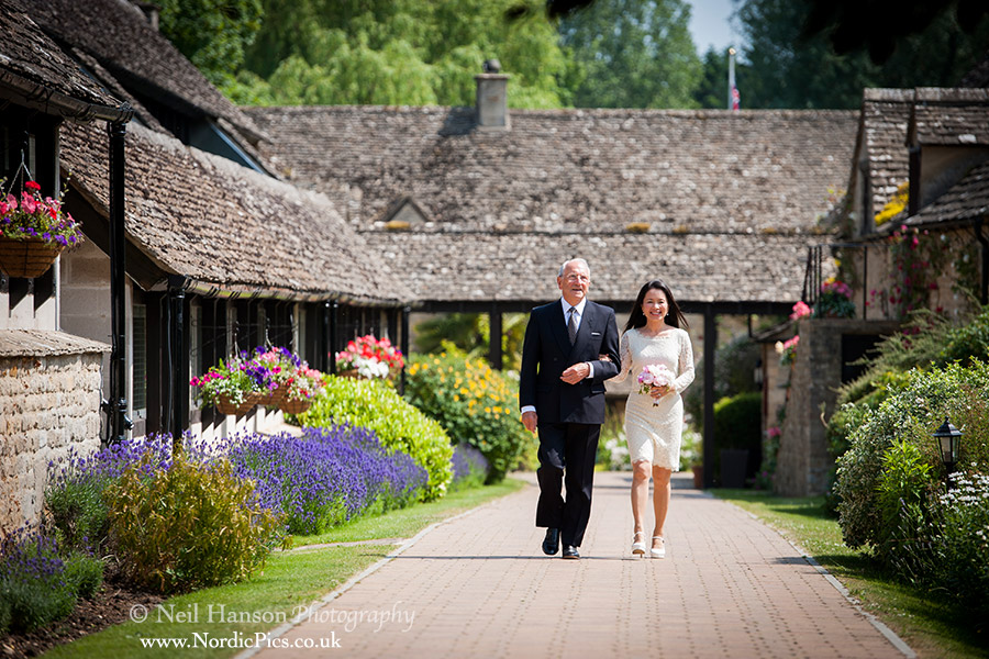 Bride walking to her outdoor wedding ceremony at the Old Swan and Minster Mill