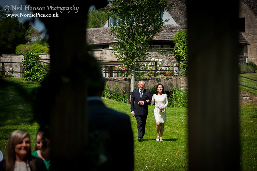Bride Walking to her wedding ceremony at the old swan and minster mill in minster lovell oxfordshire