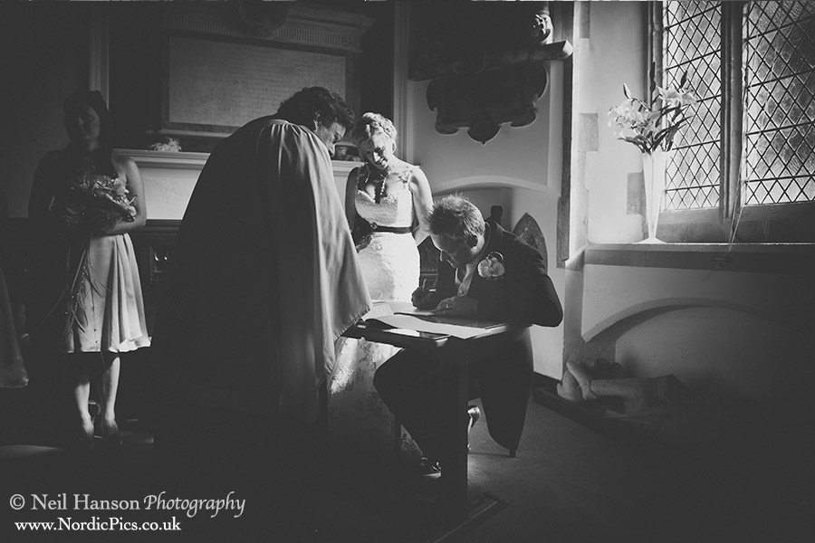 Bride & Groom signing the register at a Wedding at St George's Church Georgham