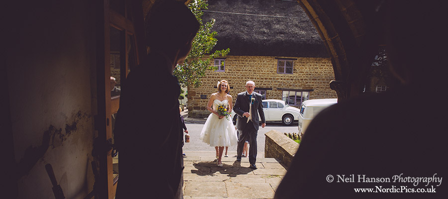 Bride and father of the bride entering St Peters Church Hook Norton before the Wedding ceremony