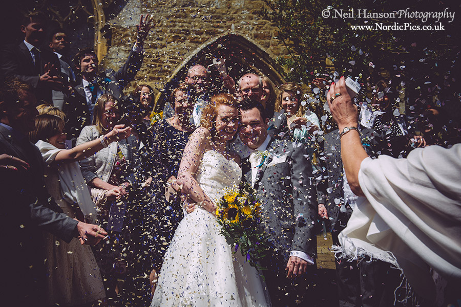 Mass confetti throwing following the wedding at St Peters Church Hook Norton