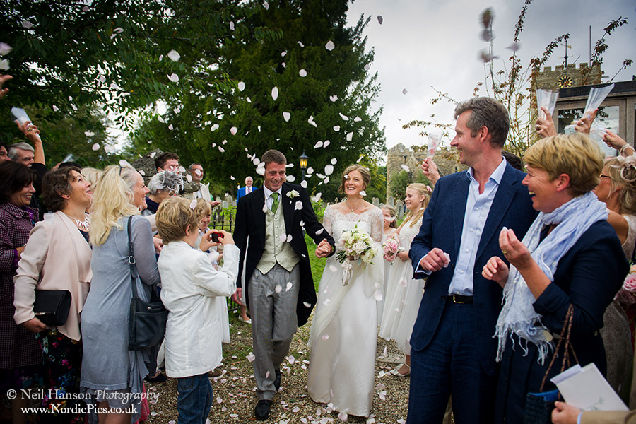 Bride & groom at Buckland Church guests throwing confetti