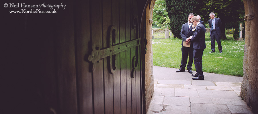 Groom waiting to greet guests at St Marys Church Cogges