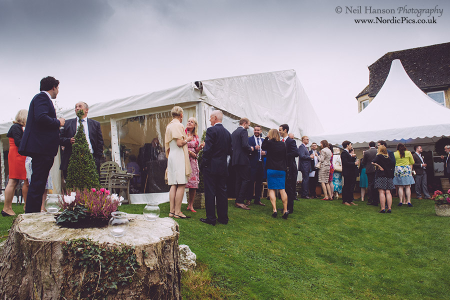 Guests mingling outside a farm marquee wedding in oxfordshire