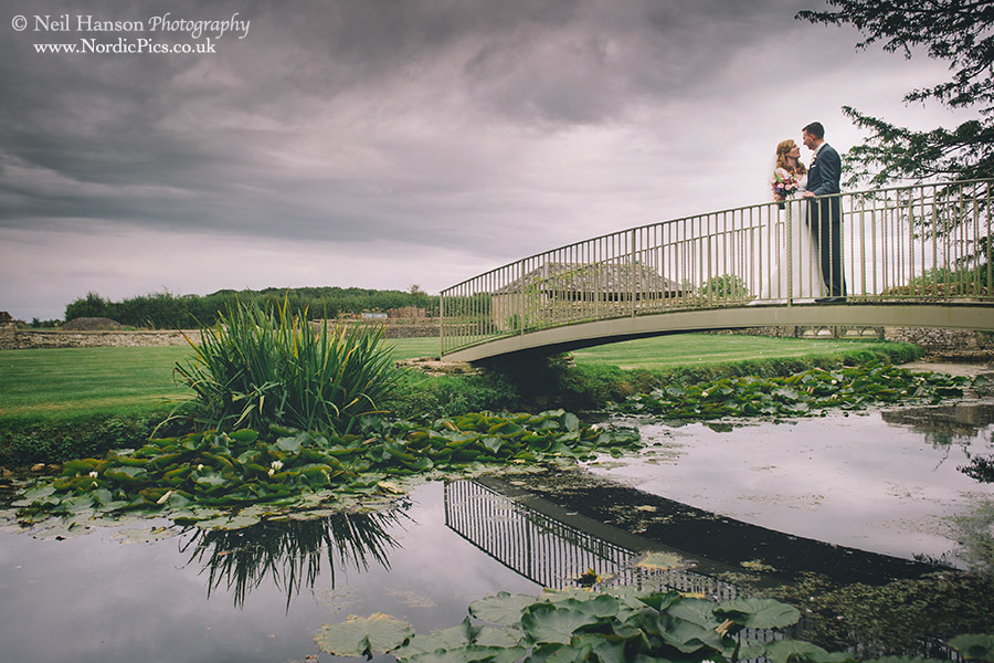 Bride & groom on the bride over the moat at their Caswell House Wedding in Oxfordshire