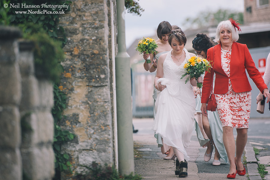 Bride walking to a wedding ceremony at Cogges Farm Museum in Witney