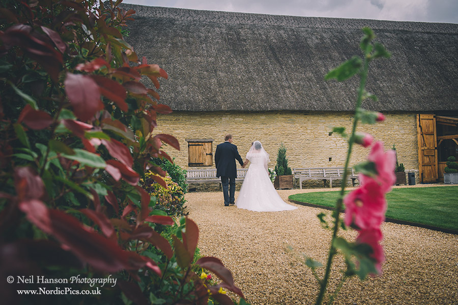 Bride & groom walking in the grounds of The Tythe Barn Launton