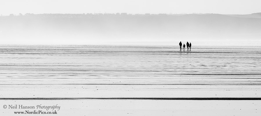family walks on the beach