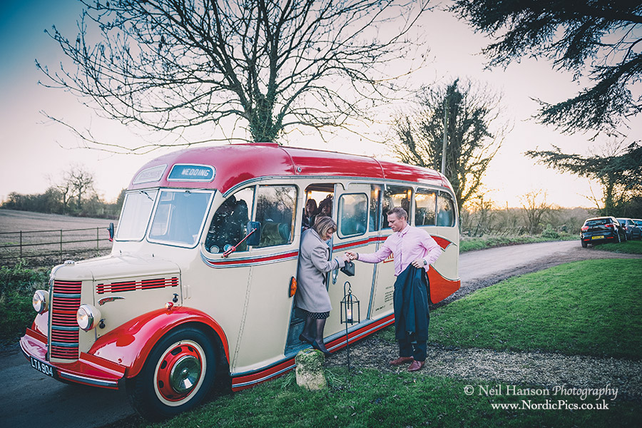Wedding guests arriving at Little Barrington Church in a Vintage Bus