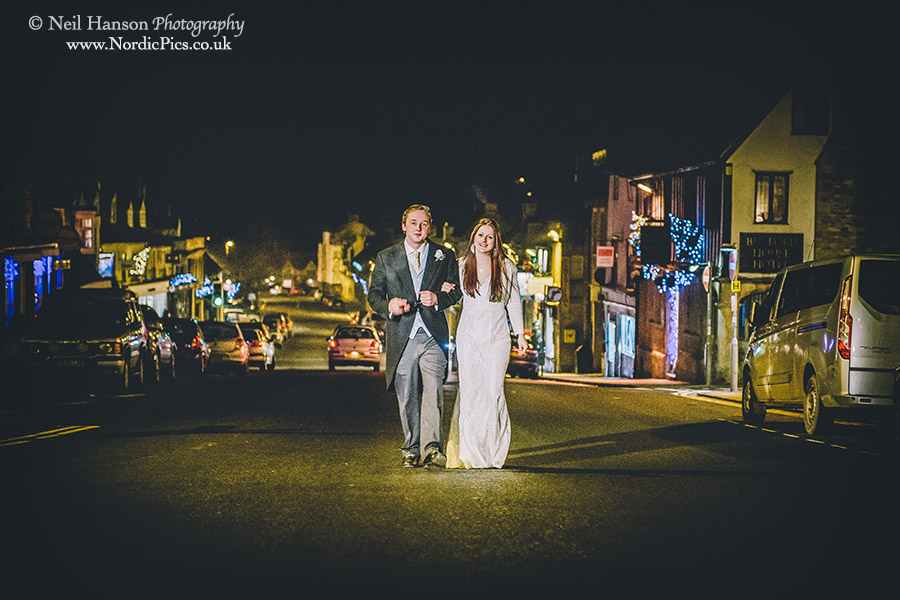 Bride & groom walking down Burford High Street at Night