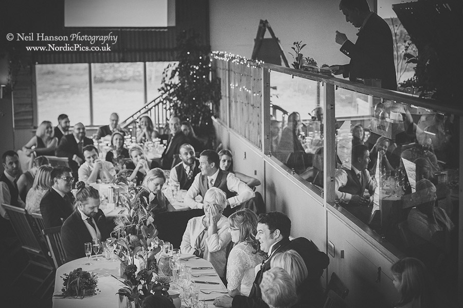 Wedding guests enjoying the speeches in the Dutch Barn at Cripps Stone Barn