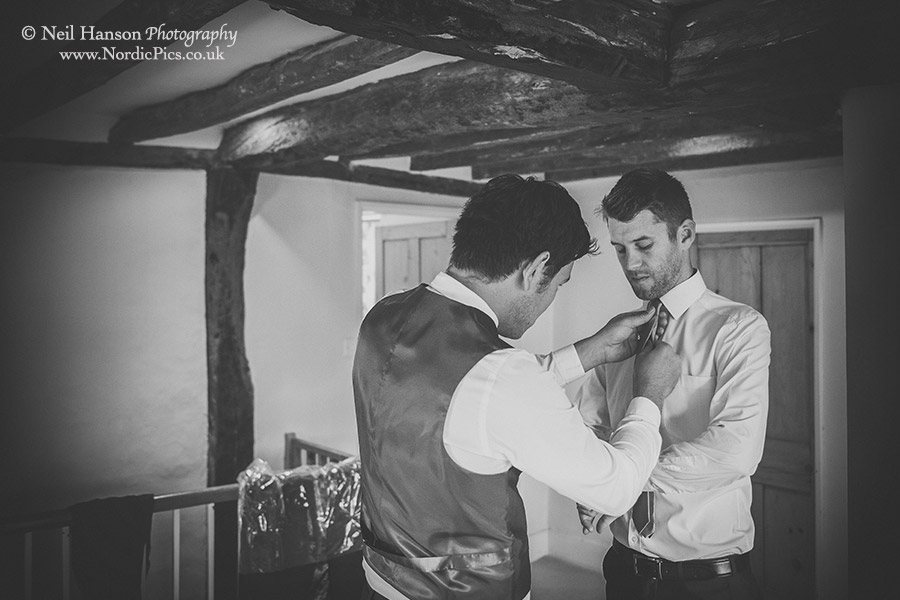 Groom being helped by his best man in the morning of his Wedding at Worton Hall