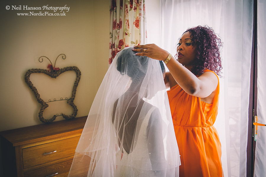 Bridesmaid putting on the brides veil