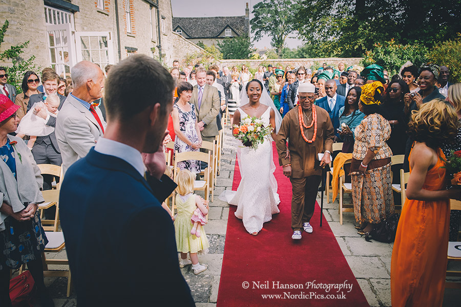 Bride and her father walking down the isle at an outdoor ceremony at Worton hall Wedding