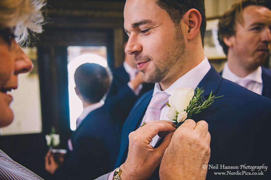 Grooms buttonhole being put on