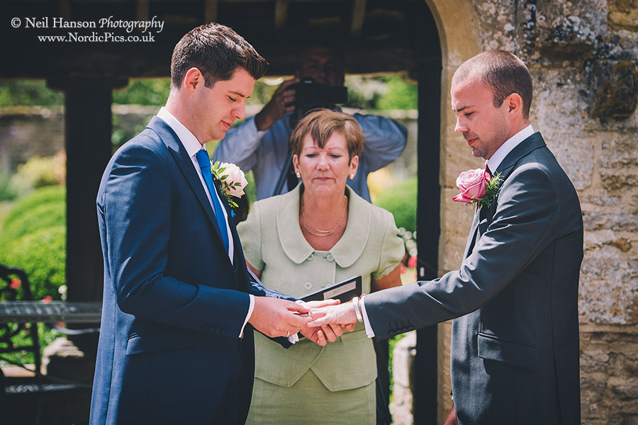 Grooms exchange rings at a same sex wedding ceremony at caswell house