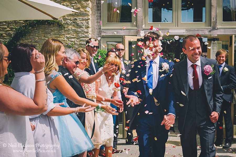 Guests throwing confetti on a same sex wedding at Caswell House in Oxfordshire