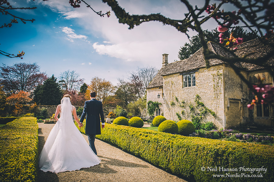 Bride and Groom walking in Caswell House Gardens