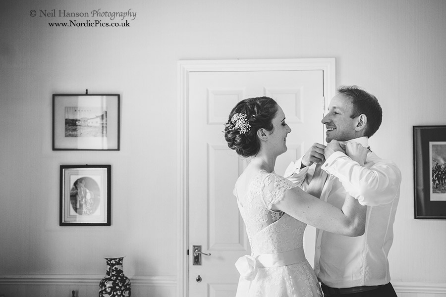 Bride helping the groom do his bow tie