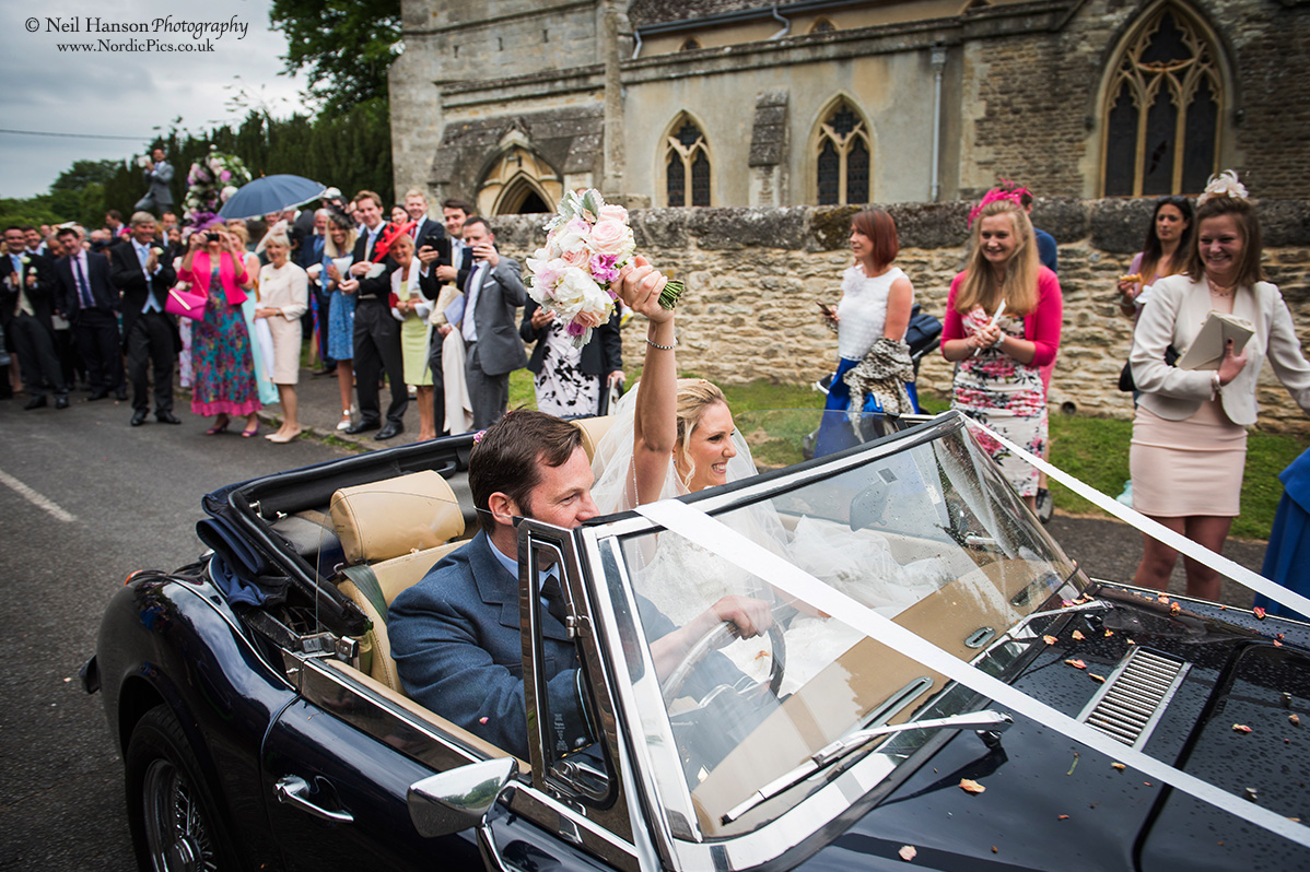Bride and Groom leave their church in a sports car