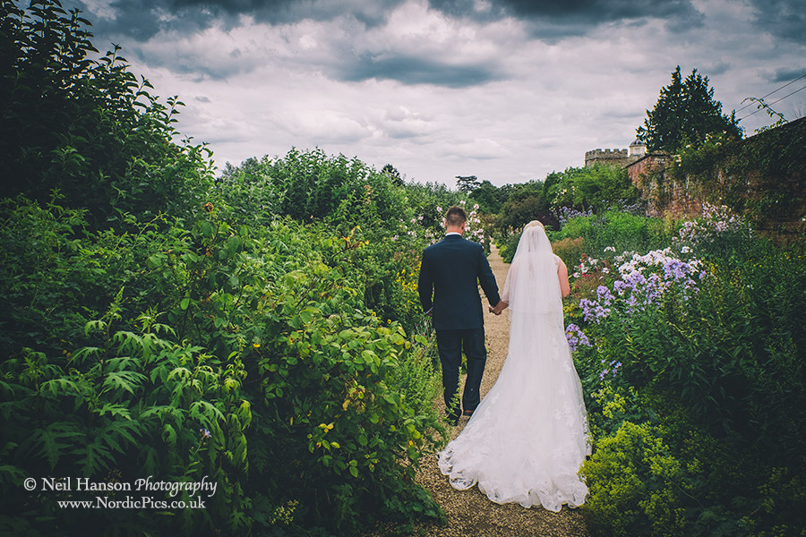 Bride and groom walking in the gardens of Rousham House in Oxfordshire