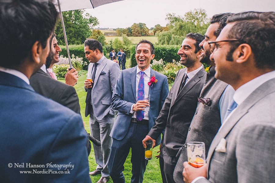 Groom laughing with wedding guests