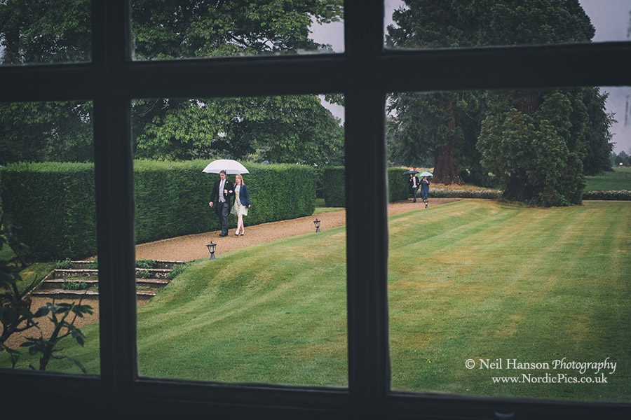 Guests arriving at Kingston Bagpuize House on a wet wedding day