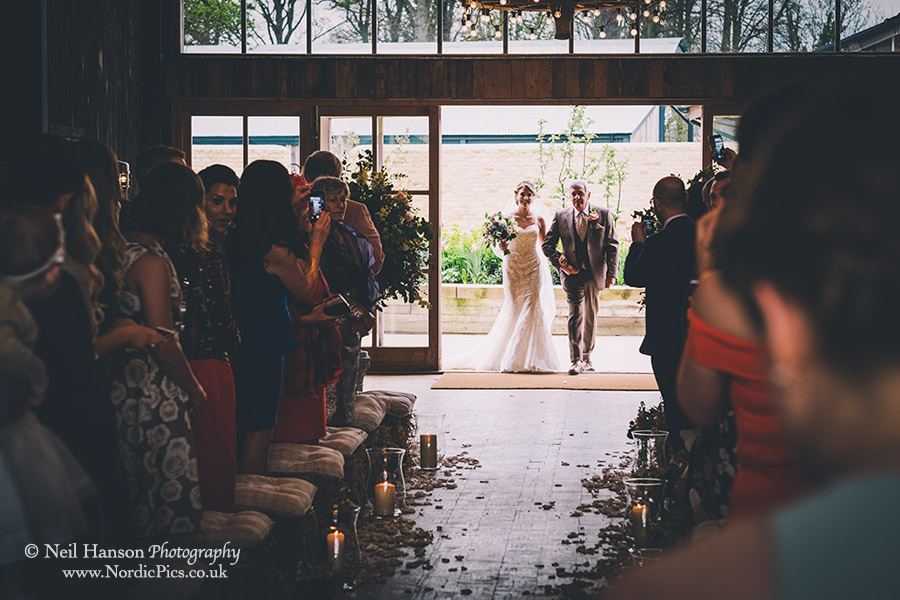 Bride and her Father enter the wedding ceremony in the Hay Barn at Soho Farmhouse