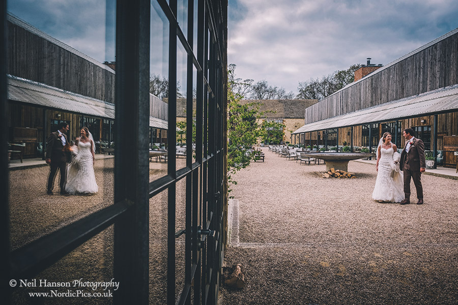 Bride and Groom walking through the main courtyard at Soho Farmhouse