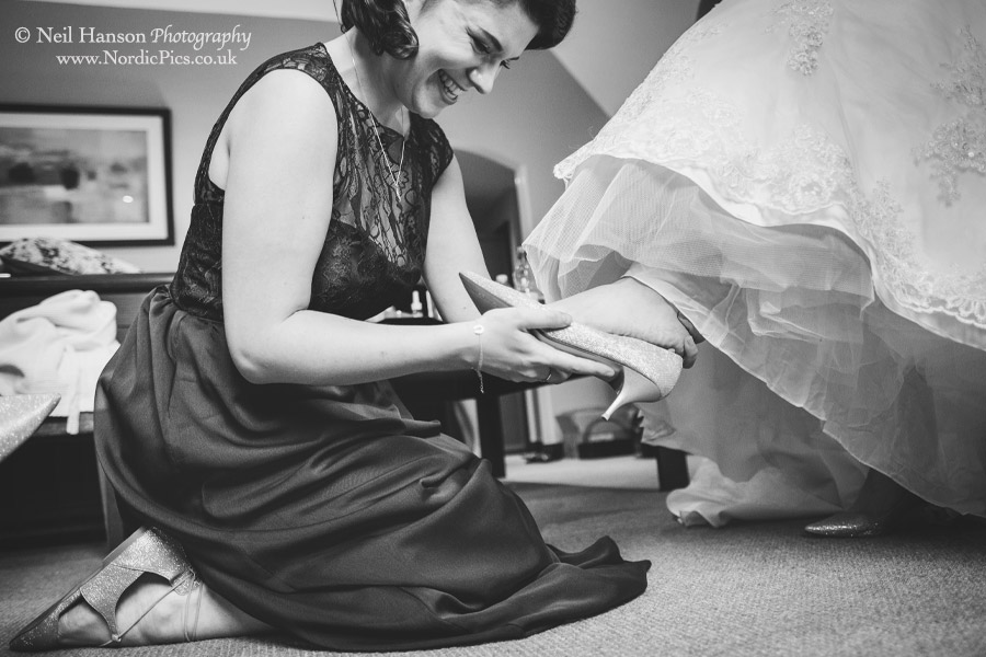 Bridesmaid helping to put the Brides shoes on