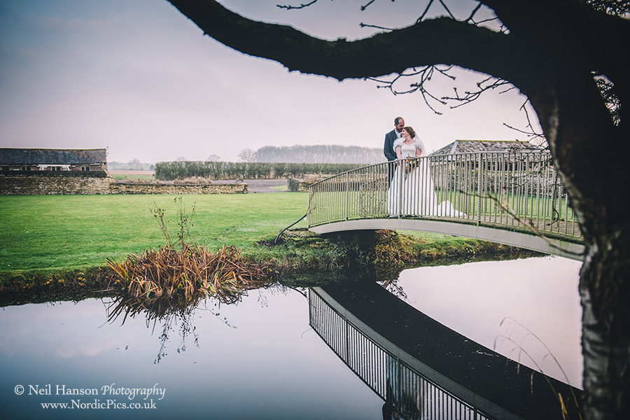 Bride and Groom on the bridge at Caswell House