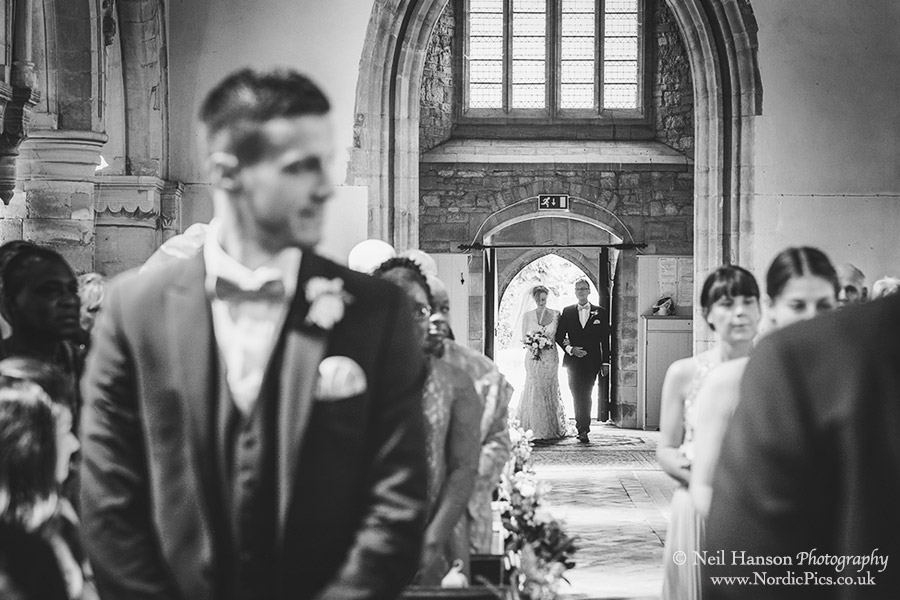 The bride and father enter Waddesdon Church for the wedding ceremony
