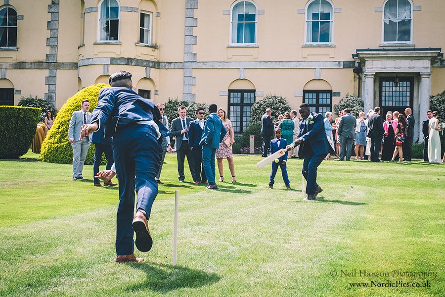 Wedding guests playing Cricket on the lawns of Hampden House in Buckinghamshire