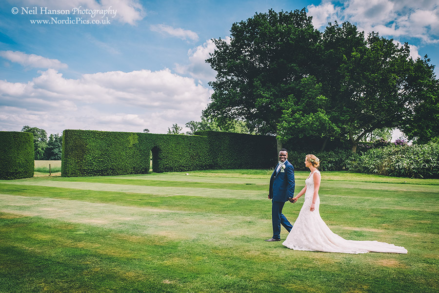 Bride and Groom walking in the grounds of Hampden House on their Wedding day