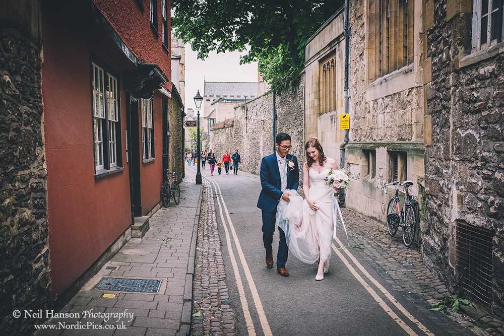 Bride and Groom walk the street of Oxford on their Wedding Day