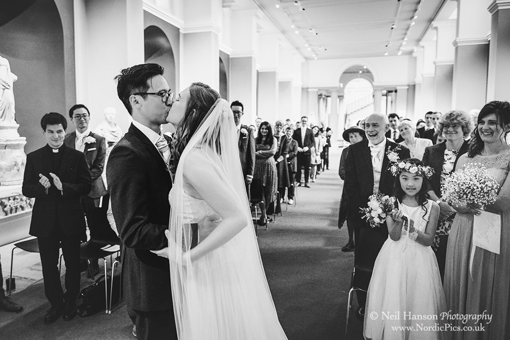 bride and Groom kiss during their wedding ceremony at the Ashmolean museum