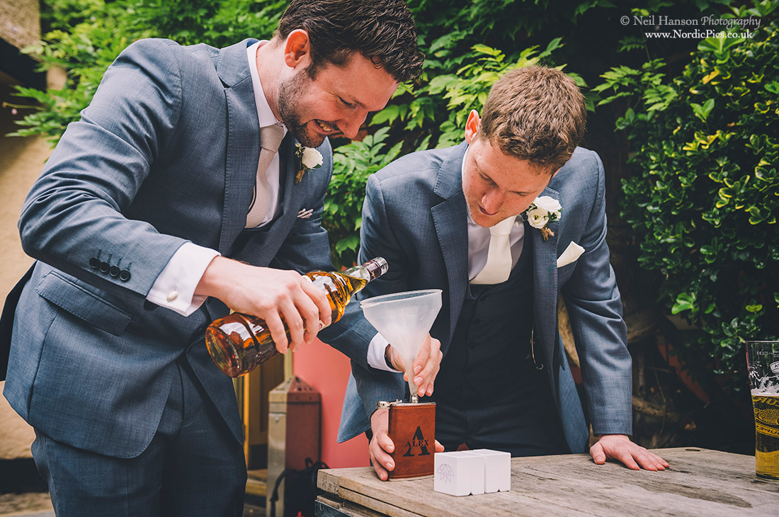 Groom and Best man filling their hip flasks with Whiskey