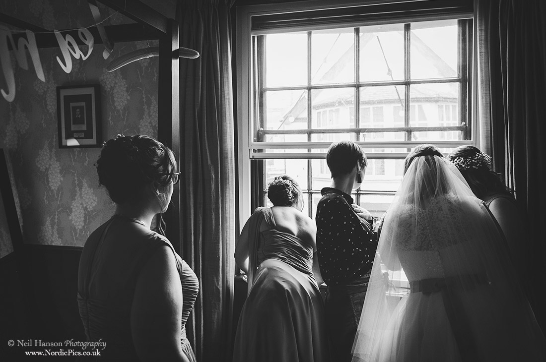 bride and Bridesmaids watching wedding guests arrive at The Crown and Thistle Abingdon