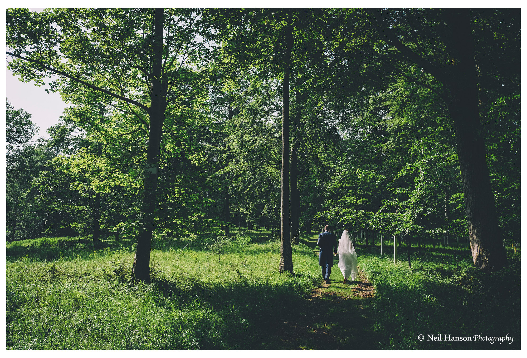 Bride and Groom walk back to Old Luxters Barn through the woods