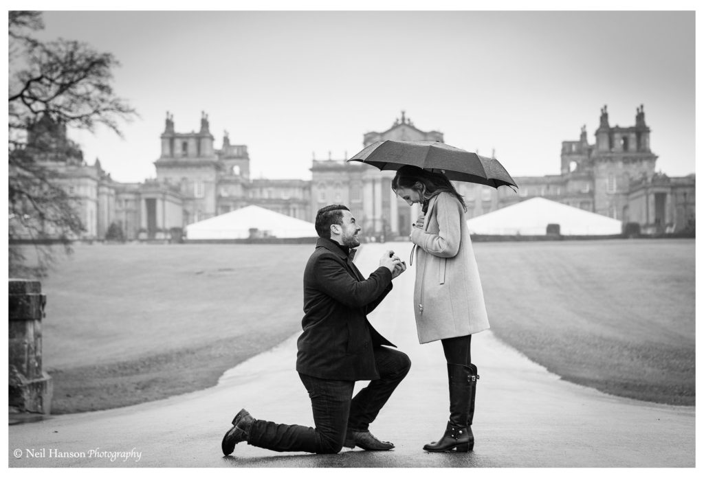 On one knee proposing to his partner at Blenheim Palace